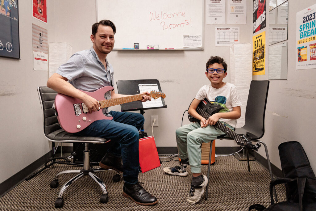 Student taking guitar lessons with teacher at Mason Music