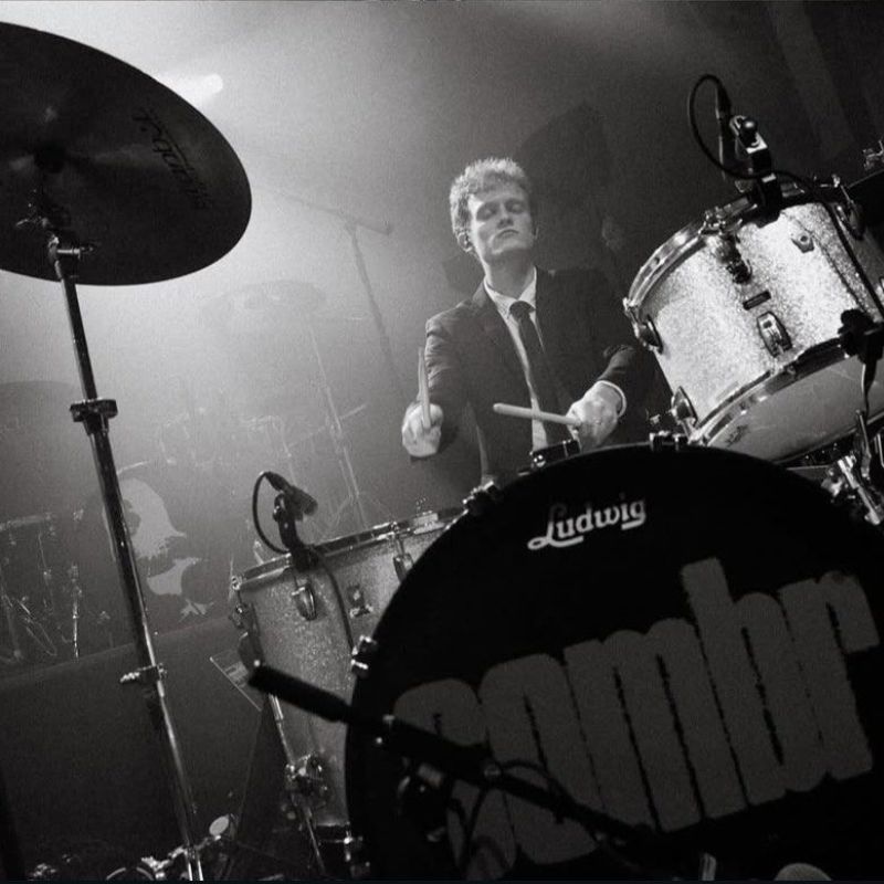 Photo of Sombr drummer Mitch Prewitt performing on stage.